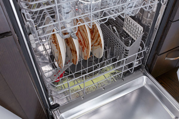 Dishwasher with Dirty Dishes and Glisten detergent booster in bottom