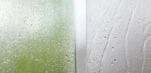 Spray cleaner foam running down clear plastic wall