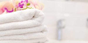 Stack of white towels with pink flowers on top