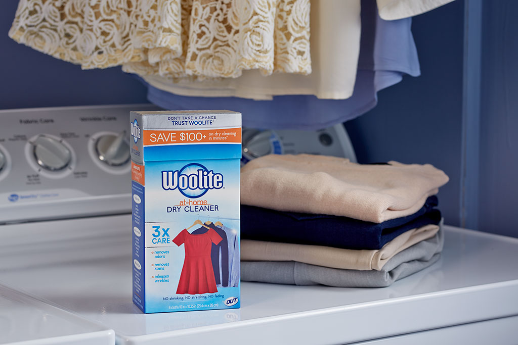 Woolite home dry cleaning kit on washer with clean laundry